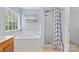 Bright bathroom showcasing a soaking tub and a shower with a stylish curtain at 9010 Davis Crossing Ct, Charlotte, NC 28269