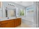 Bright bathroom with double vanity, soaking tub, and a window providing natural light at 9010 Davis Crossing Ct, Charlotte, NC 28269