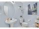 Stylish powder room featuring a pedestal sink, round mirror, floating shelves, and fresh blue walls at 9010 Davis Crossing Ct, Charlotte, NC 28269