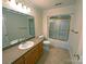 Bright bathroom featuring a single sink vanity, toilet, and bathtub with shower and gold trim at 904 3Rd Street Ne Pl, Conover, NC 28613