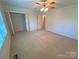 Spacious bedroom with ceiling fan, closet, and neutral carpet at 904 3Rd Street Ne Pl, Conover, NC 28613