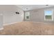 Bright bedroom featuring two windows, carpeted floor, and a wall mount ready for a tv at 9303 Raven Top Dr, Mint Hill, NC 28227