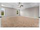 Bright bedroom with a ceiling fan, carpet flooring, and windows providing natural light at 9303 Raven Top Dr, Mint Hill, NC 28227