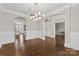 Elegant dining room featuring hardwood floors, wainscoting, arched doorways, and modern lighting at 9303 Raven Top Dr, Mint Hill, NC 28227