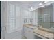 Bathroom vanity featuring granite countertops, white cabinets, and a bright window with plantation shutters at 9803 Tree Canopy Rd, Charlotte, NC 28277