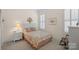 Cozy bedroom with a colorful bedspread, plantation shutters, and a traditional rocking chair at 9803 Tree Canopy Rd, Charlotte, NC 28277
