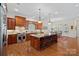 Spacious kitchen features a large island with seating, stainless steel appliances, and custom cabinetry at 9803 Tree Canopy Rd, Charlotte, NC 28277