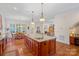 Open concept kitchen with large island, pendant lights, and seamless flow to the dining and living areas at 9803 Tree Canopy Rd, Charlotte, NC 28277
