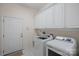 Well-organized laundry room with white cabinets, modern washer and dryer, and a convenient utility sink at 9803 Tree Canopy Rd, Charlotte, NC 28277
