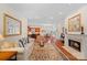 Bright, open-concept living room showcasing a fireplace, hardwood floors, and seamless flow to the kitchen at 9803 Tree Canopy Rd, Charlotte, NC 28277
