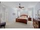 Spacious main bedroom with a wooden sleigh bed, ceiling fan, plantation shutters, and ensuite bathroom at 9803 Tree Canopy Rd, Charlotte, NC 28277