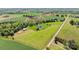 Expansive aerial view of a white farmhouse, pastures, outbuildings, and idyllic farmland at 1065 Hunter Bridge Rd, Stony Point, NC 28678