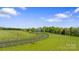 Picturesque property with a winding driveway, lush green fields, and mature trees at 1065 Hunter Bridge Rd, Stony Point, NC 28678