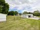 Spacious backyard with green lawn, utility buildings and mature trees, all enclosed by a black chain link fence at 109 Georgia Belle Ave # 199, Belmont, NC 28012
