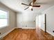 Bedroom with hardwood flooring, ceiling fan, white trim, window, and two doorways at 109 Georgia Belle Ave # 199, Belmont, NC 28012