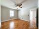 Bedroom with hardwood flooring, ceiling fan, white trim, window, and two doorways at 109 Georgia Belle Ave # 199, Belmont, NC 28012