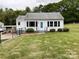 Charming home with a well-maintained lawn, black fence, and a pop of color from the front door at 109 Georgia Belle Ave # 199, Belmont, NC 28012