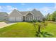 Charming home featuring a three-car garage, manicured lawn, and inviting double-door entry at 11228 Island View Ln, Lancaster, SC 29720