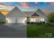 Inviting home with a two-car garage, manicured lawn, and charming entry under a colorful sky at 11228 Island View Ln, Lancaster, SC 29720