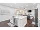 Open-concept kitchen island with stainless steel appliances, connecting to a living room with a fireplace at 11228 Island View Ln, Lancaster, SC 29720