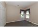 Neutral bedroom featuring carpet, natural light, and closet for comfortable living at 115 Players Park Cir, Statesville, NC 28677