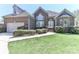 Charming brick home features a manicured lawn, lush bushes, and an attached two-car garage at 115 Players Park Cir, Statesville, NC 28677