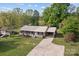 Aerial view of a brick home, showing the metal roof, a manicured yard, and mature trees at 1195 Ralph B Keener Rd, Lincolnton, NC 28092