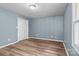 A clean bedroom is shown with fresh paint, light toned wood floors, and a bright window at 1195 Ralph B Keener Rd, Lincolnton, NC 28092