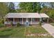 Charming brick home featuring a cozy front porch with white railing and a metal roof at 1195 Ralph B Keener Rd, Lincolnton, NC 28092