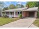 Charming single-story red brick home featuring a metal roof, a front porch, and a long concrete driveway at 1195 Ralph B Keener Rd, Lincolnton, NC 28092