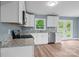 Open kitchen with new stainless steel appliances, granite countertops, white cabinets, and a view to the yard at 1195 Ralph B Keener Rd, Lincolnton, NC 28092