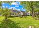 Spacious backyard with well-maintained lawn, mature trees, and patio area, providing a serene outdoor space at 12305 Portrush Ln, Charlotte, NC 28273