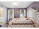 This charming main bedroom features neutral carpet, two windows, and an attached ensuite bathroom at 12305 Portrush Ln, Charlotte, NC 28273