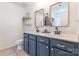Modern bathroom with dual sinks, navy cabinets, and bright light fixtures at 13015 Rothe House Rd, Charlotte, NC 28273