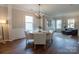 Elegant dining room featuring hardwood floors, a chandelier, and large windows offering ample natural light at 13015 Rothe House Rd, Charlotte, NC 28273