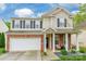 Charming two-story home with a stone facade, inviting front porch, and well-maintained landscaping at 13015 Rothe House Rd, Charlotte, NC 28273