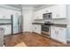 Bright kitchen features stainless steel appliances, white cabinets, and wood flooring at 13015 Rothe House Rd, Charlotte, NC 28273
