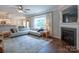 Open-concept living area with a fireplace, hardwood floors, large windows, and a view of the kitchen at 13015 Rothe House Rd, Charlotte, NC 28273