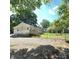 View of back of home and yard with a wooden deck and chain link fence surrounding the property at 1307 Washington Ln, Kannapolis, NC 28083