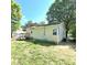 View of the back of the home, which includes a wooden deck, and a grassy backyard and trees at 1307 Washington Ln, Kannapolis, NC 28083