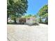 Inviting one-story home with a covered porch and gravel driveway, nestled among mature trees at 1307 Washington Ln, Kannapolis, NC 28083