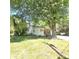 View of front exterior and front yard with covered porch and gravel driveway and mature tree at 1307 Washington Ln, Kannapolis, NC 28083