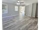 Bright living room with wood-look floors, ceiling fan, and access to the front porch at 1307 Washington Ln, Kannapolis, NC 28083
