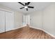 Bedroom features fan, neutral walls, and wood floor. View to hallway at 13324 Kintyre Ct, Matthews, NC 28105