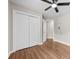 Bedroom features fan, neutral walls, and wood floor. View to hallway and closet at 13324 Kintyre Ct, Matthews, NC 28105
