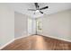 Bedroom features fan, neutral walls, and wood floor. View to bathroom at 13324 Kintyre Ct, Matthews, NC 28105