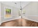 Dining area filled with natural light, featuring wood floors and modern pendant lighting fixture at 13324 Kintyre Ct, Matthews, NC 28105