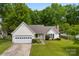 Charming single-story home with a manicured lawn, a two-car garage, and inviting front porch at 13324 Kintyre Ct, Matthews, NC 28105