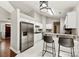 Open kitchen features white cabinets, stainless steel appliances, and a breakfast bar with pendant lighting at 13324 Kintyre Ct, Matthews, NC 28105