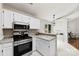 Charming kitchen features white cabinetry, stainless steel appliances, and a breakfast bar overlooking the dining area at 13324 Kintyre Ct, Matthews, NC 28105